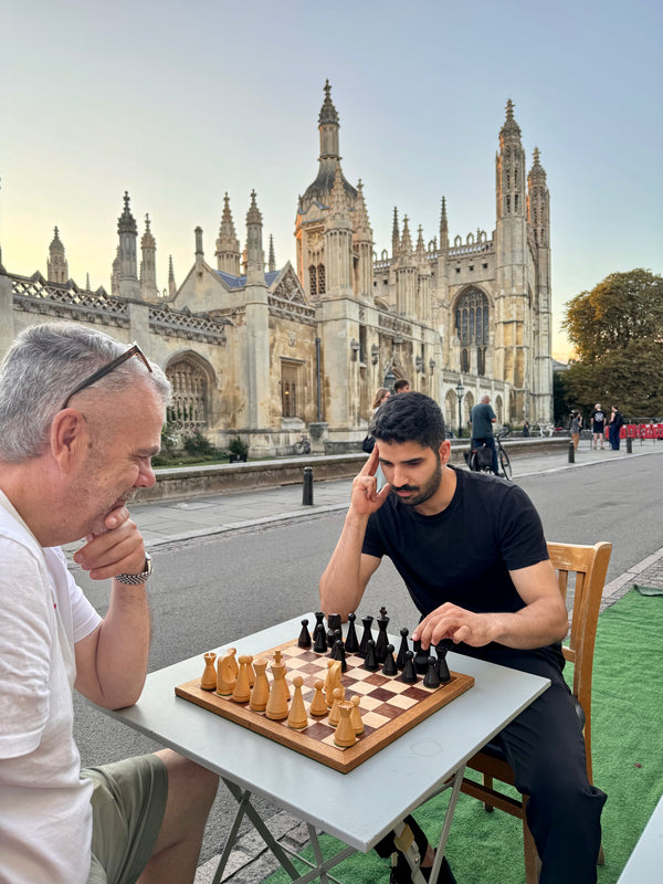 Two men playing chess in front of Kings College Cambridge