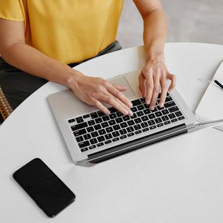 Women in yellow top typing on laptop