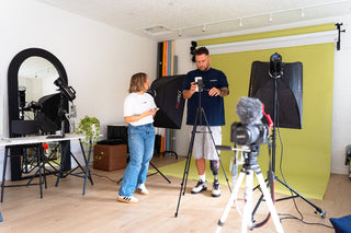 2 people in a photo studio with photography equipment 
